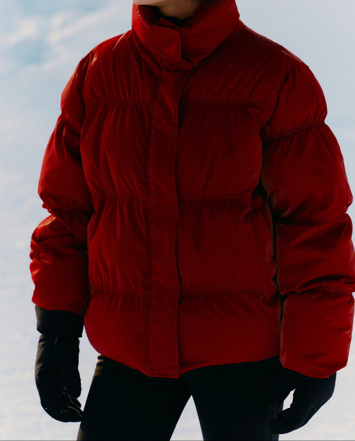 Person wearing a red puffer jacket in a snowy landscape